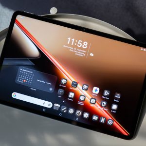 Ein Honor Pad X9 Max liegt mit angeschaltetem Display, auf dem der Homescreen zu sehen ist, auf einem Beistelltisch.