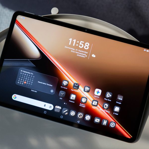 Ein Honor Pad X9 Max liegt mit angeschaltetem Display, auf dem der Homescreen zu sehen ist, auf einem Beistelltisch.