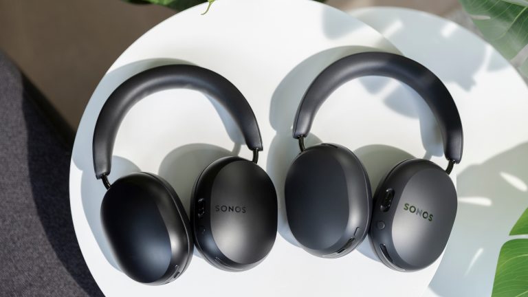 Die Sonos Ace und die Sonos Ace Ultra in Schwarz liegen nebeneinander auf einem Tisch.
