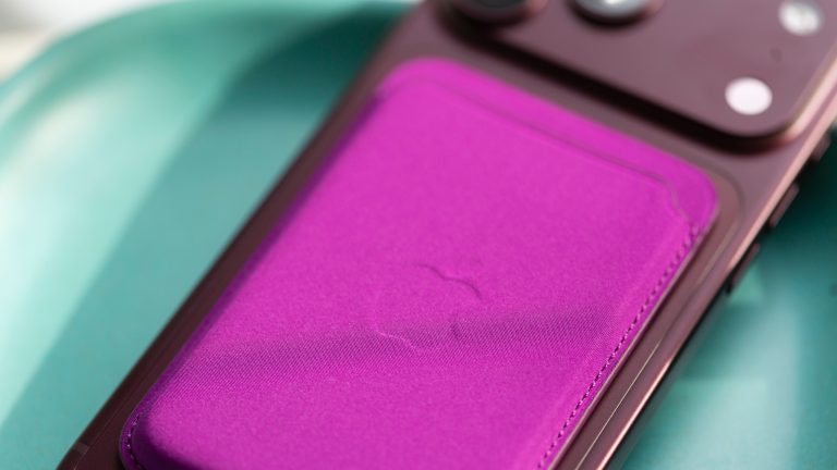 Ein Apple Feingewebe-Wallet in Magenta an der R&uuml;ckseite eines iPhone 18 Pro Max.