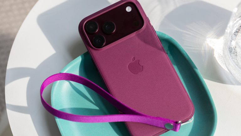 Eine Trageschlaufe in Magenta an einem Feingewebe-Case von Apple.