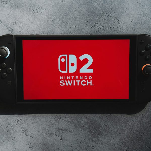 Eine Nintendo Switch 2 liegt auf einer Stein-Oberfläche, auf den Screen ist das Logo der Konsole zu sehen.