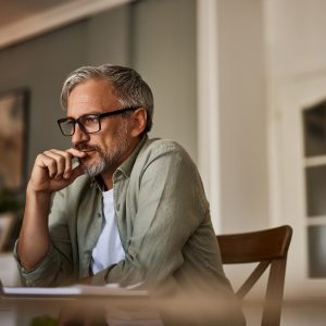 Eine Person sitzt an einem Tisch und arbeitet an einem Notebook
